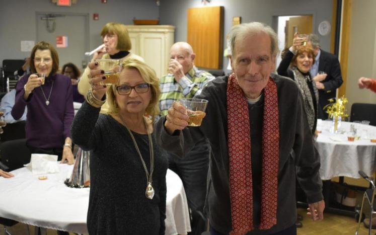 Lee Schmidt, left, and John Bones raised their glasses to celebrate the coming of 2018 during the center’s annual New Year’s...