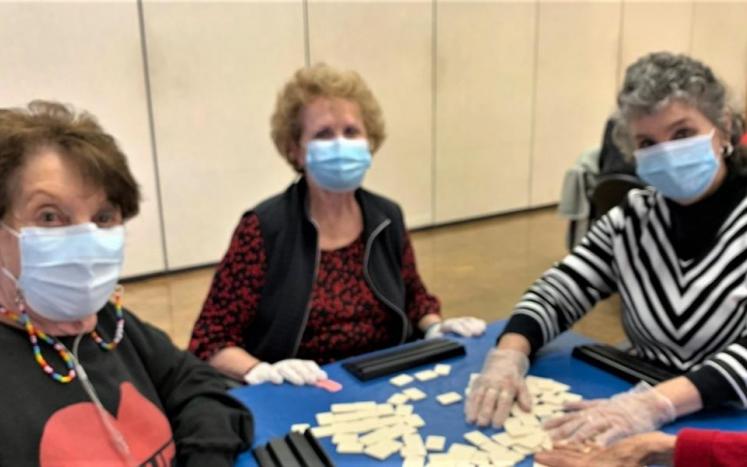 Three women in masks playing a game