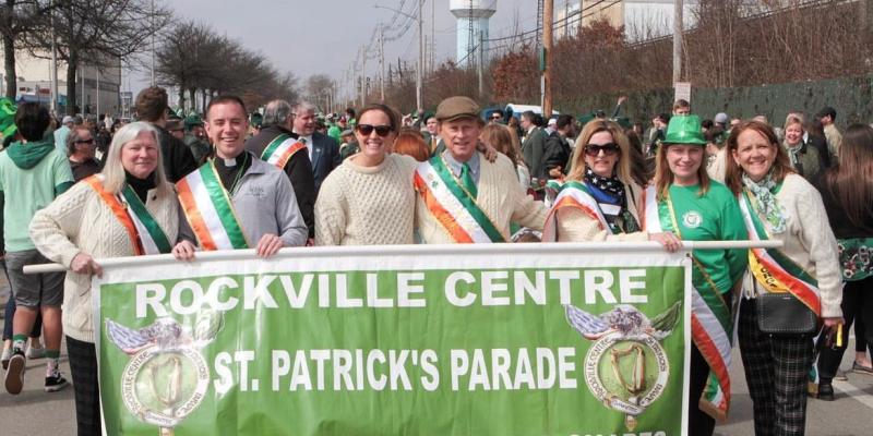 A group of people behind the parade banner